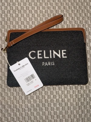 Celine Paris svart kuvertväska - Stilren svart kuvertväska från Celine Paris. Köpt från vestiaire collective i ny skick och har inte använt en ända gång efter jag köpt, har tyvärr aldrig kommit till användning. Har pris lappar kvar och lappen som visar att den är äkta och att vestiaire har kollat den IGNACIO heter dom som kollar äktheten på varor. Kan sälja för 4300 om man kan mötas i Stockholm 