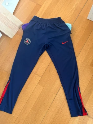 Blå PSG träningsbyxor/track byxor S - Inga defekter, passar i längden för folk upp till 180cm. Dragkedjorna funkar på alla ställen. Hör gärna av vid frågor.