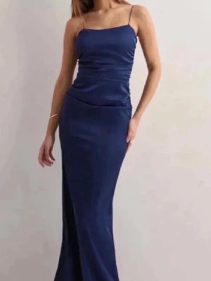 Marinblå långklänning Nelly  - Säljer min mörkblåa balklänning från Nelly köpt förra året.   Klänningen är i storlek 34 men är uppsydd (se bild 3). Längden är mätt som på bild 2 och är ca 126cm. Den är använd 1 gång och har inga defekter. 💕