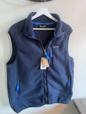 Patagonia väst - Säljer min patagonia väst då den var lite för liten i nytt skick. Den är mörkblå med ljusblåa detaljer. Storlek L men eftersom att många använder kläder under kan nog en M passa också. Hör av er vid funderingar eller frågor. Fraktar inom 24h📦🚚