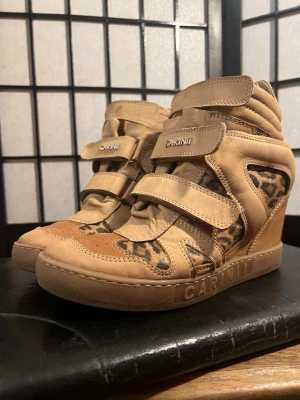 Vintage wedge sneakers leopard Carinii beige läder Y2K aesthetic -  “Beige wedge sneakers med leoparddetaljer 🐆✨ Ger dig direkt den där ‘effortless cool girl’-looken. Perfekta till low rise jeans eller leggings + hoodie 🤍  Hidden wedge så du får lite extra height utan att det syns 👀  Storlek 38 Bra skick – normalt slitage (se bilder)”  📦 Skickas snabbt 🔥 Nytt inne varje vecka 💬 Bud & bundle välkomnas