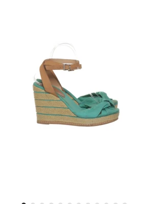 Turkosa kilklackssandaler med knut - Snygga sandaler med turkos textil, knut framtill och kilklack i flätad jute. Remmar i brunt läderimitation med spänne runt ankeln. Perfekta för sommaren och ger en cool boho-vibe till din outfit.