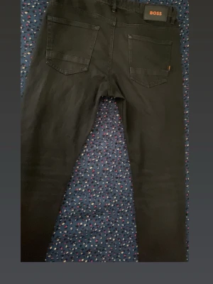 Svarta jeans från BOSS - Snygga svarta jeans från BOSs, köpt för över 2000kr de är äkta och det är storlek 33/32