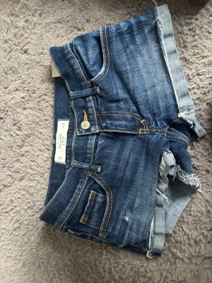 Super låga jeansshorts blå snygg jeans färg  - Knappt använda midjemått ca 34,5cm. Lågmidjade jeans shorts mörkblå fadead färg 