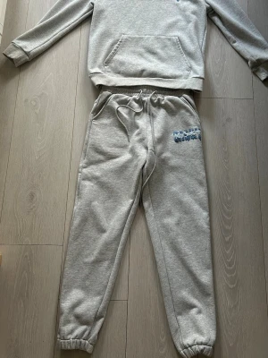 Grå mjukisbyxor med tryck - Säljer ett grått set från Risky! Superfint skick och väldigt bekvämt material! Perfekt både till vardags och en mer uppklädd casual look.  