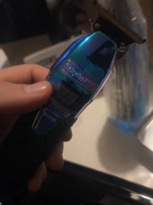 BaByliss pro 4Artists Boost+ ChameleonFX Trimmer - Pris kan förvandlas, Professionell sladdlös precisionstrimmer kan även användas med sladd Förnyad kraftfull borstlös motor med hög hastighet och vridmoment med en effekt på 7200 rpm Förnyat 3300 mAh litiumjonbatteri med en drifttid på 4 timmar Förnyat DLC Deep-Tooth T-bladsskärblad Justerbar utan mellanrum Öppet skärhuvud för 360° fri sikt Snygg mattsvart med metallhölje och diamantformat gummihandtag