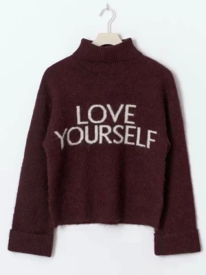 Polo tröja ifrån gina tricot❤️ - Mysig vinröd stickad tröja med hög krage och uppvikta ärmslut. På bröstet står det 'LOVE YOURSELF' i vit text. Tröjan har en avslappnad passform och är perfekt för kalla dagar. Materialet ser ut att vara mjukt och fluffigt.