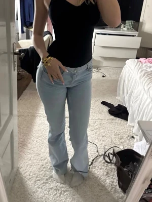 Ljusblå lågmidjade bootcut jeans  - Säljer ett par ljusblå bootcut jeans från Zara med klassisk femficksdesign och låg midja. Jeansen har en snygg tvätt och är tillverkade i mjuk denim med lite stretch för skön passform. Perfekta för en avslappnad och trendig look. I storlek 38 men passar 36.  