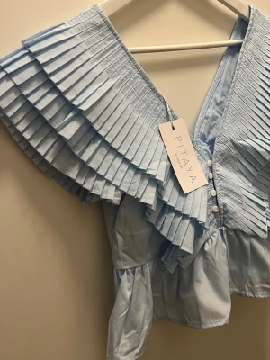 Volang topp - Trendig ljusblå volang topp från Pitaya💙slutsåld!!