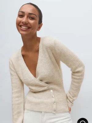 Alpacka blend kofta  - Snygg beige omlottkofta med djup v-ringning och dekorativa pärlemorknappar längs sidan. Nästan helt slutsåld på hemsidan!!💝Köpt för 460kr