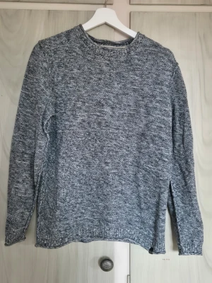 Gråmelerad stickad tröja Jack & Jones - Säljer en gråmelerad stickad tröja från Jack & Jones. Tröjan har rund halsringning, långa ärmar och ribbstickade muddar. Materialet är mjukt och bekvämt, perfekt för kyligare dagar. Enkel och stilren design som passar till det mesta.    Alla kläder rollas innan dom skickas hem då det finns katt i hemmet🐈 Jag stryker och tvättar INTE innan jag skickar det får du stå för själv så det blir som du vill ha det🤗