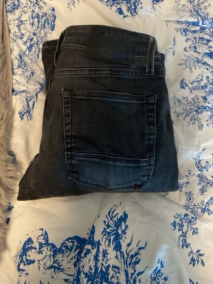 Svarta slitna jeans med raka ben - Säljer ett par svarta jeans med slitningar och raka ben. Jeansen har klassisk femficksdesign och en lätt tvättad look. Perfekta för en avslappnad och trendig stil. Materialet är denim med lite stretch för extra komfort. Priset är ej hugget i sten så bara att skriva om man är sugen!!!