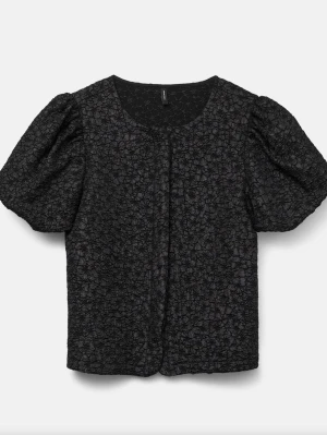 Svart blus med puffärm och struktur - Säljer en svart blus med korta puffärmar och ett strukturerat, blommigt mönster. Blusen har rund halsringning och en rak passform som ger en trendig look. Slutsåld på deras hemsida, använd 3 gånger. Som nytt skick❤️❤️