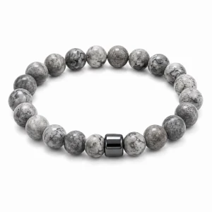 Grått armband med marmorerade pärlor - Snyggt armband med rundade, marmorerade pärlor i olika grå nyanser och en metallisk detalj i mitten. Pärlorna är trädda på en elastisk tråd vilket gör det enkelt att ta på och av. Perfekt accessoar för dig som gillar stilrena och moderna smycken.