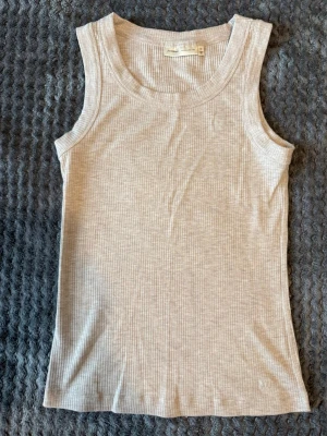 Ljusgrå ribbad linnetopp från InWear - Säljer en ljusgrå ribbad linnetopp från InWear. Toppen är ärmlös med rund halsringning och har en slim passform. Perfekt att styla till jeans eller kjol för en enkel och clean look. Nypris är 400kr!