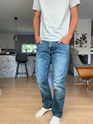 BLÅ RAKA NUDIE JEANS”STEDDIE EDDIE” - Säljer ett par riktigt snygga Nudie jeans till ett extremt bra pris. Dem är i prima skick och har inga skador eller nått på sig. Hör av dig vid minsta fråga✌️längd 101 cm och midja 39-40