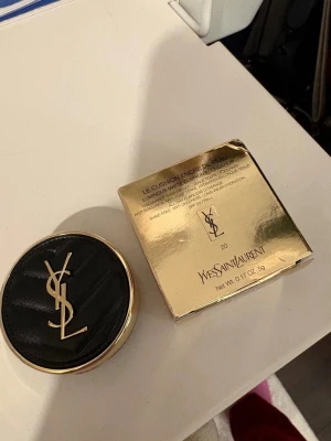 Foundation - Helt ny oöppnad, medföljer sminkpuff med logga, finns spegel inuti. Nyansen ”20”