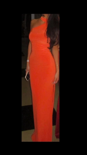 Orange one shoulder festklänning - Säljer en snygg orange festklänning med oneshoulder-design och smickrande tight passform. Klänningen har ett coolt asymmetriskt snitt vid halsen och är tillverkad i ett mjukt, stretchigt syntetmaterial som sitter bekvämt mot kroppen. Perfekt till bal, bröllop, fest och högtider. Endast använd en gång ‼️materialet är stretchig så passar allt från xxs-s