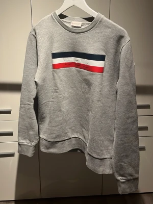 Grå sweatshirt från Moncler (ÄKTA) - Säljer min moncler tröja som legat hemma i 1 år och är för stor för mig, enda anledningen de inte blivit använd 