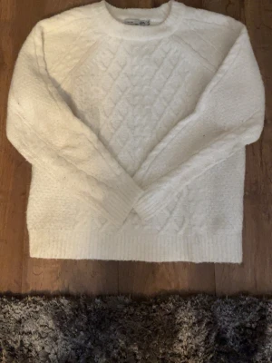 Vit stickad tröja från 157 - Mysig stickad tröja från 157 med diamantmönster framtill. Perfekt för kalla dagar och enkel att matcha med olika outfits. Hör av er vid frågor eller intresse!