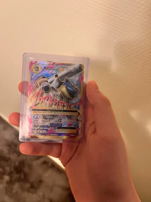 Pokémonkort Mega Blastoise EX - Säljer ett coolt Pokémonkort Mega Blastoise EX med 220 HP, i en skyddande plastficka. Kortet har färgstarka holografiska detaljer och japansk text. Perfekt för samlare eller Pokémon-fans som vill utöka sin samling.