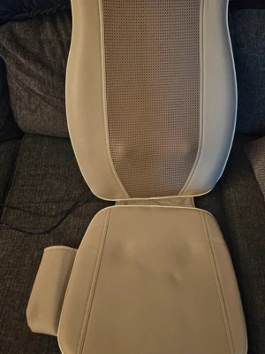 Massagekudde med fjärrkontroll nytt - Nytt aldrig använt.                                   Elektronisk massagekudde i konstläder med perforerat tyg i mitten. Medföljande fjärrkontroll har funktioner för shiatsu, rolling, spot, neck och lower massage samt justerbar bredd. Perfekt för avkoppling i soffan eller på kontoret.  