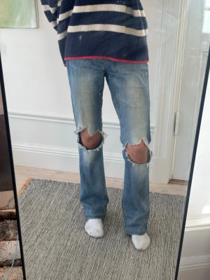 Supersnygga lågmidjade jeans med slitningar - Säljer ett par lågmidjade ljusblå jeans med slitningar vid knäna🩵 Från Vila i strl S🩵