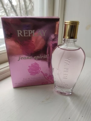 Replay Jeans Spirit For Her EdT  - Se flaska för mängd. Replay Jeans Spirit For Her EdT är en modern och mild parfym som beskrivs som en avslappnad floral komposition. Doften öppnar med ultrafeminina noter av pion för att sedan övergå i ett hjärta som fylls med varma noter av ingefära och saftig passionsfrukt. Jeans Spirit For Her landar slutligen i en bas med pigga och uppfriskande noter av viol som symboliserar färgen på denim.