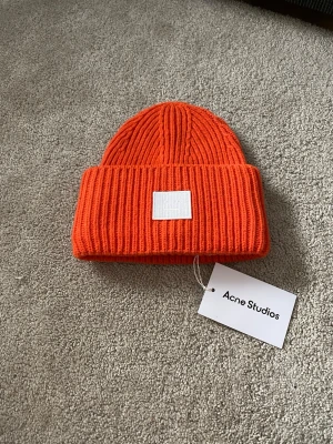 Acne Studios Ull Mössa - Orange Ull mössa från Acne Studios som håller dig varm under vintern
