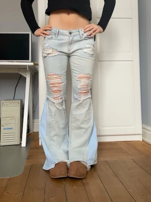 Lågmidjade ljusblå jeans med slitningar  - Säljer dessa ljsublå jeans med slitningar som är omsydda till bootcut. Midjemått 39 cm och innerbenslängd 72 cm. Kontakta mig gärna privat vid frågor eller liknande💕💕