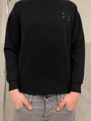 Maison Margiela svart sweatshirt - Helt ny tröja från maison margiela. Tröjan är i färgen svart och har tryck på ryggen. Tröjan är helt ny och tag sitter kvar.Tröjan är storlek S men sitter mindre. Hör av er vid frågor 🙌