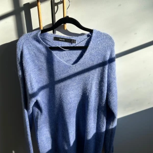 Ljusblå stickad tröja V-ringad - Mysig ljusblå stickad tröja från Veromoda med V-ringning och lång ärm. Tröjan har en avslappnad passform och är gjord i ett mjukt, fluffigt material som känns skönt mot huden. 