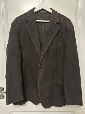 Brun kavaj från Stones - Brun Stones kavaj, strl 50. Bomull, Polyester. Ärmlängd (cm) 61 , Axelbredd (cm) 52. Urtvättad.