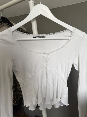Vit topp med spets och rosett Gina Tricot - Säljer en söt vit topp med spets i storlek xs från Gina Tricot, tröjan är aldrig andvänd och har inga skador🤍