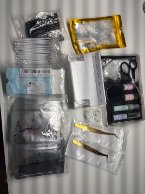 Kit för ögonfransförlängning - Komplett kit för lash & browlift  med pincetter i guld, borstar, microbrushes, pads, lim, remover, små saxar och förpackningar med vätskor. Perfekt för dig som vill fixa fransarna hemma. Innehåller flera olika verktyg och tillbehör i svart, vitt och guld.