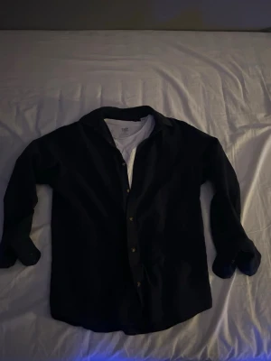 Mörkblå skjorta - Svin schysst linne skjorta ifrån Jack and Jones med storlek xs-s. Funkar perfekt med en vit T-shirt eller utan när det är som varmast. Knappt använd och har inga defekter;)