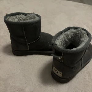 Grå boots  - Mysiga grå boots med mjukt foder. Perfekta för kalla dagar med sin varma insida och stilrena design.