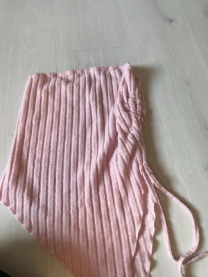 Rosa ribbad kjol från SHEIN - Supersöt ljusrosa kjol från SHEIN i ribbat material. Kjolen har snörning i sidan och en asymmetrisk form som ger en trendig look. Perfekt för dig som vill ha något unikt och bekvämt till sommaren. Materialet känns mjukt och stretchigt.