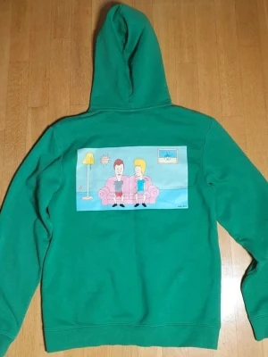 Beavis & Butt-Head Huvtröja / Hoodie | S / Small - Huvtröjja med Beavis & ButtHead tryck på framsidan (litet tryck) och baksidan (stort tryck).  Beavis & Butthead X HM (2022). Small (Mått finns på bilderna!) 60% bomull. 40% polyester.  Se bilder.