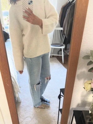 Ljusblå ripped mom jeans - Säljer ett par ljusblå mom jeans med stora slitningar vid knäna. Jeansen har en avslappnad passform och hög midja, perfekta för en trendig och avslappnad look. Inga synliga loggor eller märken. Klassisk femficksmodell och raka ben.