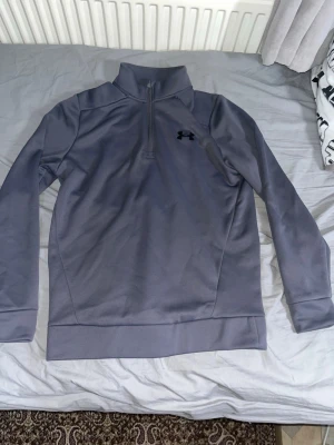 Grå half-zip tröja från Under Armour - Köpte den från under armour för en månad sen och har bara använt den ungefär 5 gånger. Den är väldigt fin och är i helt nytt skick. Om du inte är nöjd med priset så kan vi förhandla 
