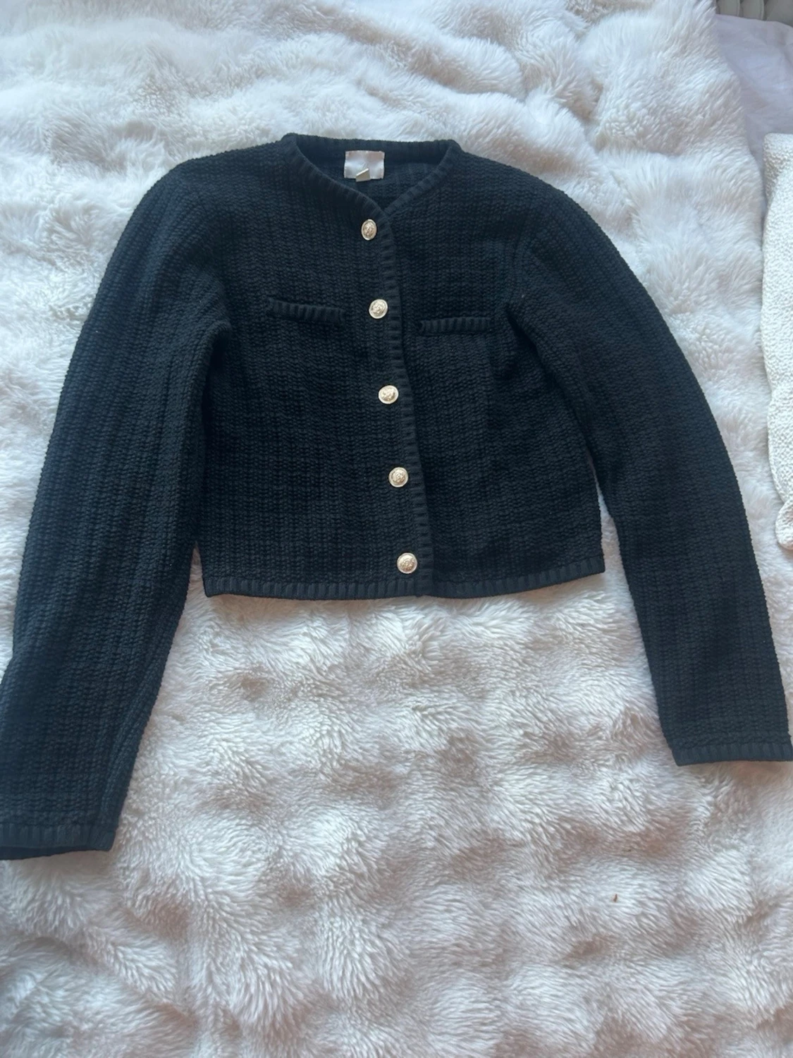 Svart kofta med guldknappar