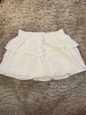 Vit kjol  - En perfekt kjol för sommaren och skolavslutning. Inte använd så mycket💕 Från Gina tricot! Vit med fina guld detaljer och pärlor på snören💕