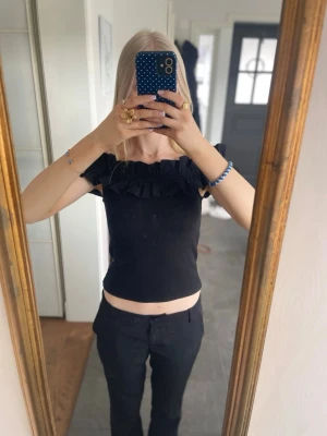 Svart volang topp - Jättefin svart ribbad off shoulder topp med volanger! Perfekt för en utekväll i varmt väder.