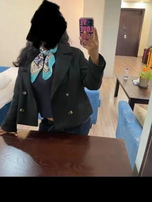 Svart kort dubbelknäppt jacka - Säljer en svart kort jacka från Vero Moda med dubbelknäppning och breda slag. Jackan har en klassisk och stilren design, perfekt att matcha med olika outfits. Materialet är mjukt och ger en snygg siluett. Passar dig som vill ha en trendig och enkel look.