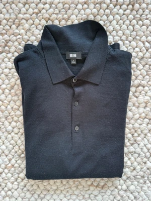 Stickad tröja uniqlo - Polo tröja från uniqlo. Bra skick litet hål vid armen och lite nopprig men annars skön och bra. Vid frågor hör av er!
