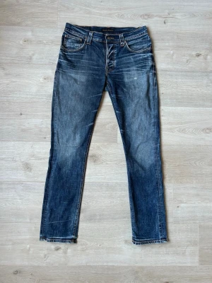 Blåa Nudie Jeans Slim Fit med Fades W34 L32 - Fina Nudie Jeans i blå färg. Jeansen är i mycket bra skick och sparsamt använda.  Äkta som allt annat jag säljer! ✅  Storlek: W34 L32 Skick: Mycket Bra Skick - lagad vid ett ställe,  (SE SISTA BILD) Färg: Blå Märke: Nudie Modell: Jeans    Hör gärna av dig vid frågor så svarar jag så fort jag kan! 😁  (SKU - 95)
