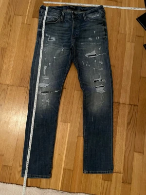 Jack & Jones jeans med slitningar - Riktigt feta jack and Jones jeans med slitningar. Byxorna är i fint skick och är riktigt bekväma. Storlek 31/32.