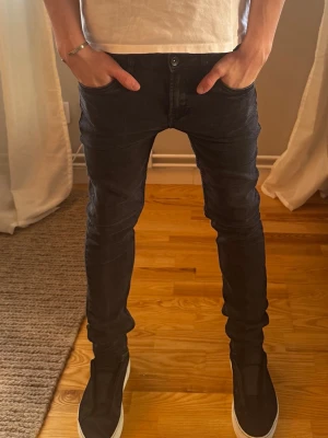 Svarta skinny jeans - Säljer ett par svarta skinny jeansfrån Garcia i Stl 164  med klassisk femficksdesign och smal passform. Jeansen har normal midja och är tillverkade i stretchigt material för extra komfort. Perfekta för en trendig och avslappnad stil.