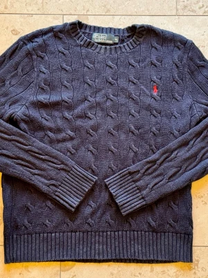 Mörkblå kabelstickad tröja Polo Ralph Lauren - Marinblå Polo Ralph Lauren stickad tröja. Bra skick inga fläckar eller hål. Storlek Medium. Skickas snabbt! Hör av er vid frågor!